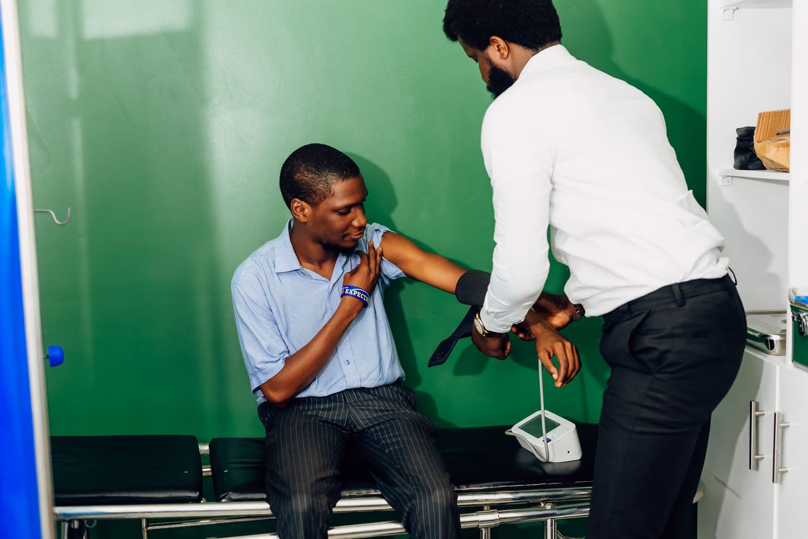 A healthcare worker checks a patient's blood pressure during a clinic visit, the kind of outpatient care SHIF contributions in Kenya are meant to cover.