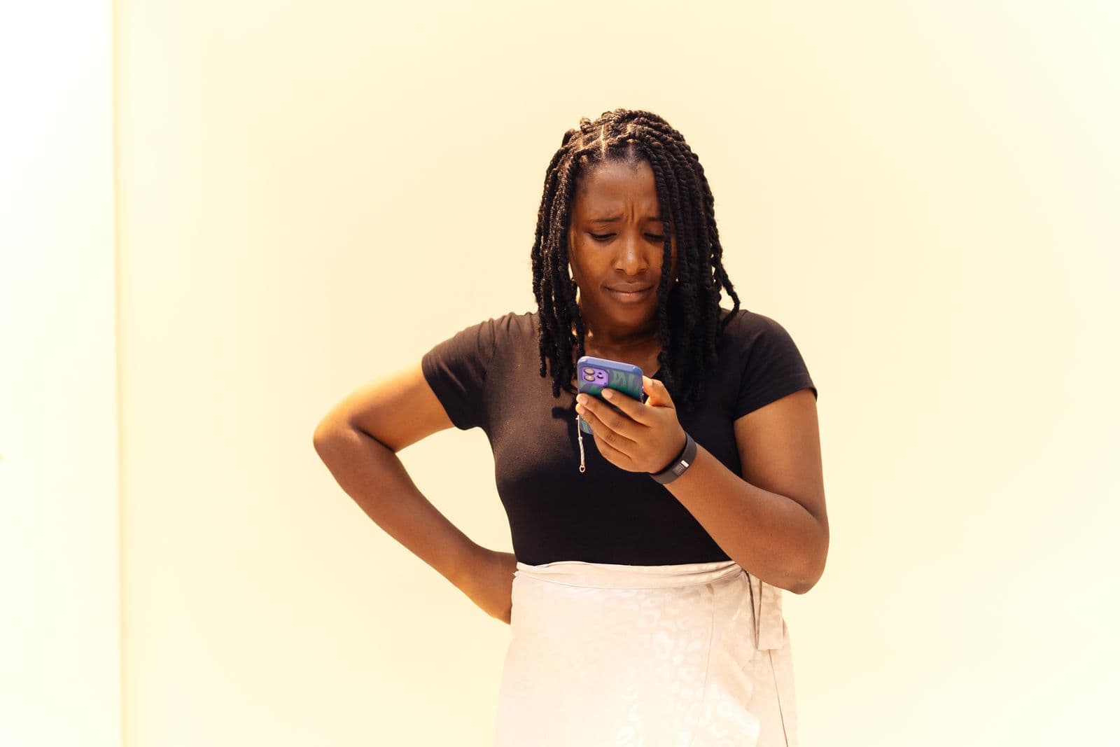 A young woman checks her phone in Lagos, Nigeria, while comparing money market fund options