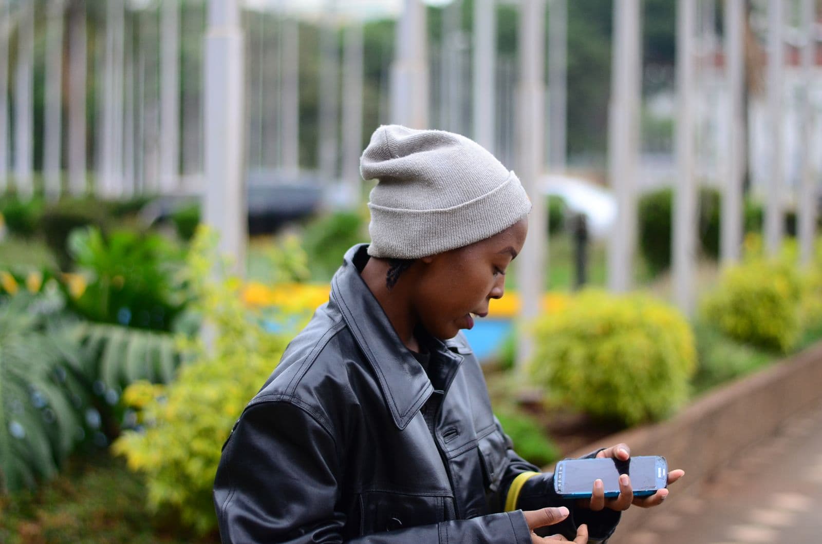 A young woman using her smartphone outdoors in Nairobi, Kenya