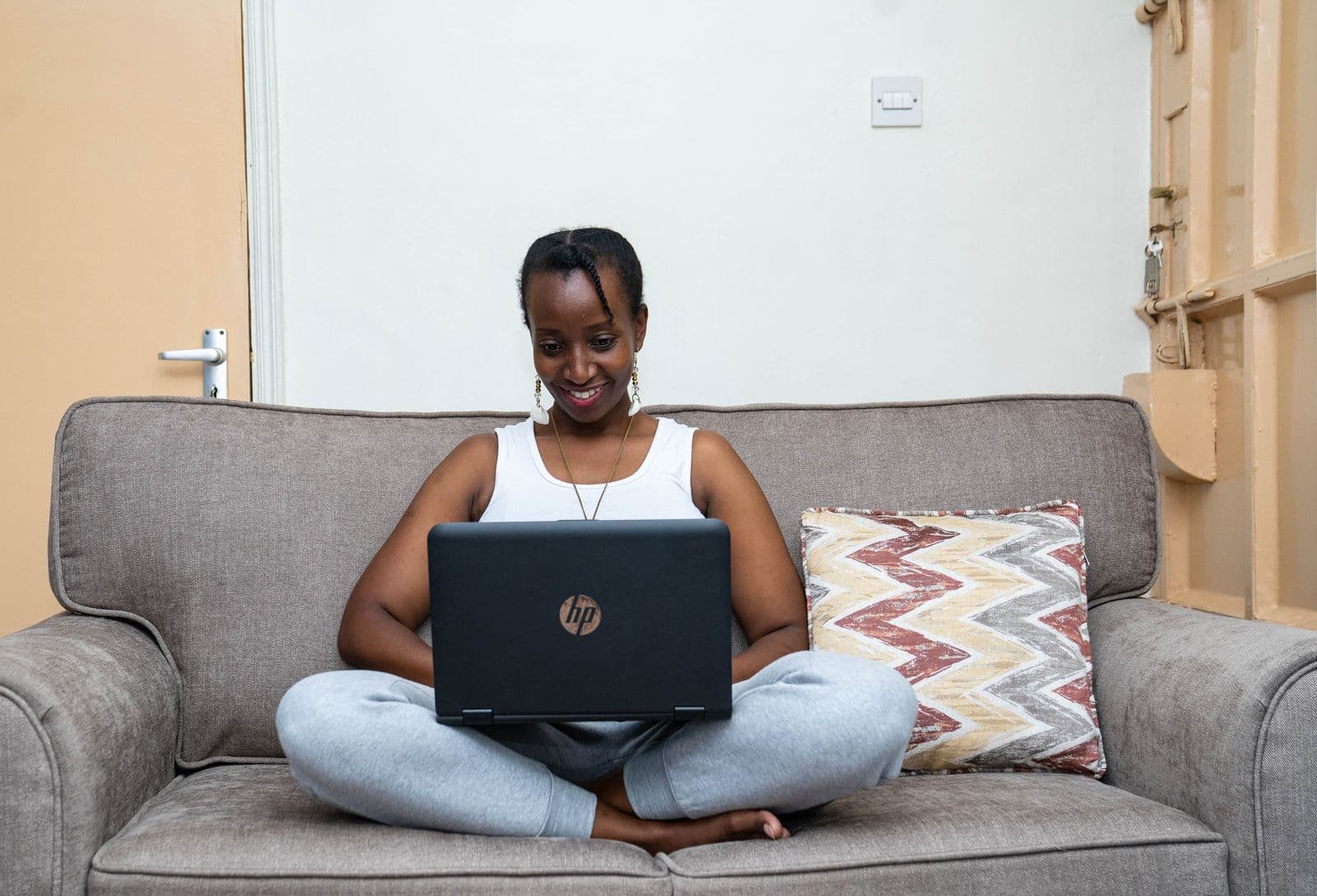 African freelancer working on a laptop from home, comparing Fiverr and Upwork earnings
