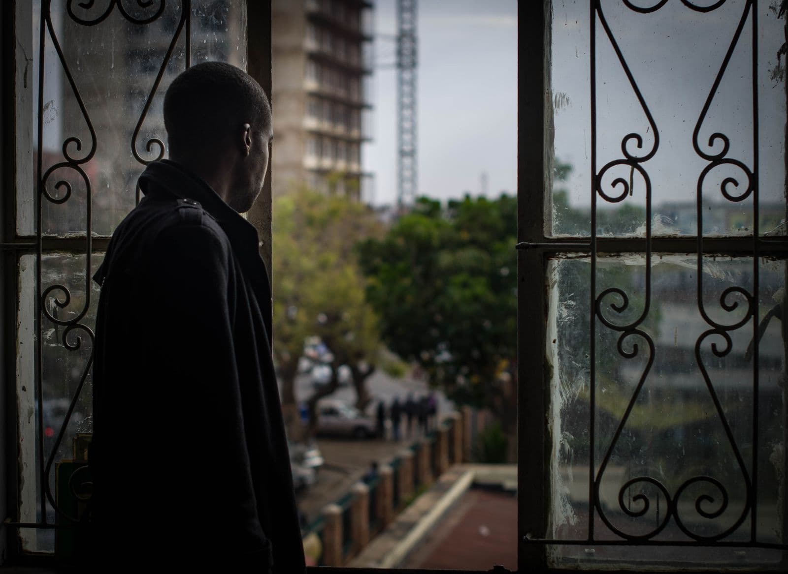 Man looking out of an office window over Lusaka, Zambia