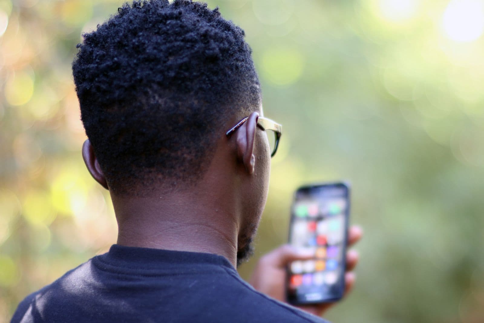 A young man in Kenya using his smartphone outdoors