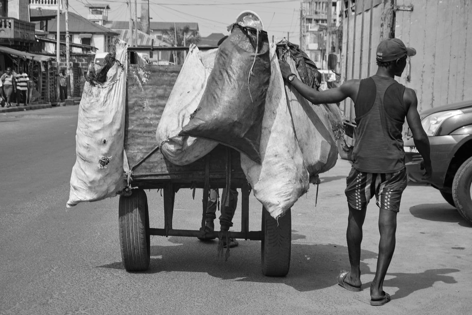 Street vendor pushing a cart of goods through a street in Sierra Leone