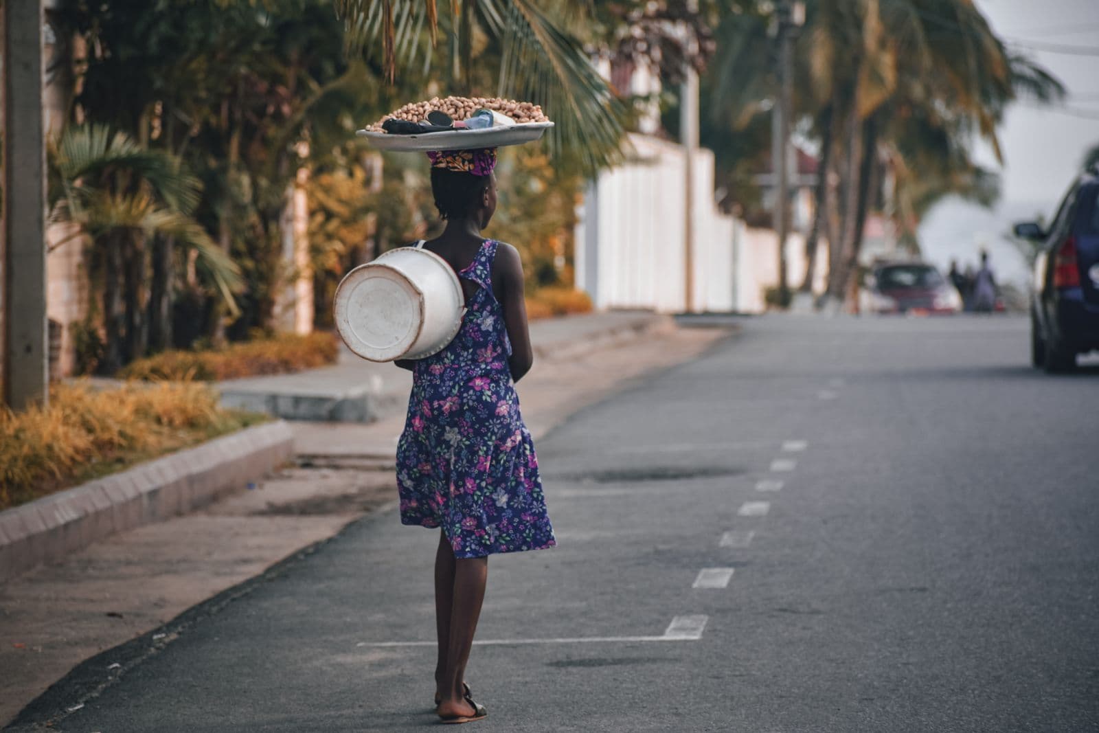 Woman carrying goods on her head along a street in Monrovia, Liberia